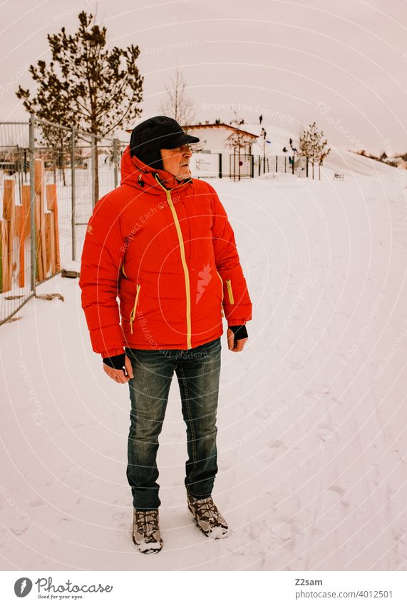 Rentner beim Winterspaziergang im Schnee winter lockdown spazieren kälte rente fit bewegung gesundheit sportlich alter mann landschaft park natur erholung