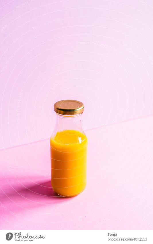 Orange juice in a glass bottle on a pink background Glassbottle segregated Breakfast Colour photo Healthy Eating Vitamin Vitamin C Food photograph Vegan diet