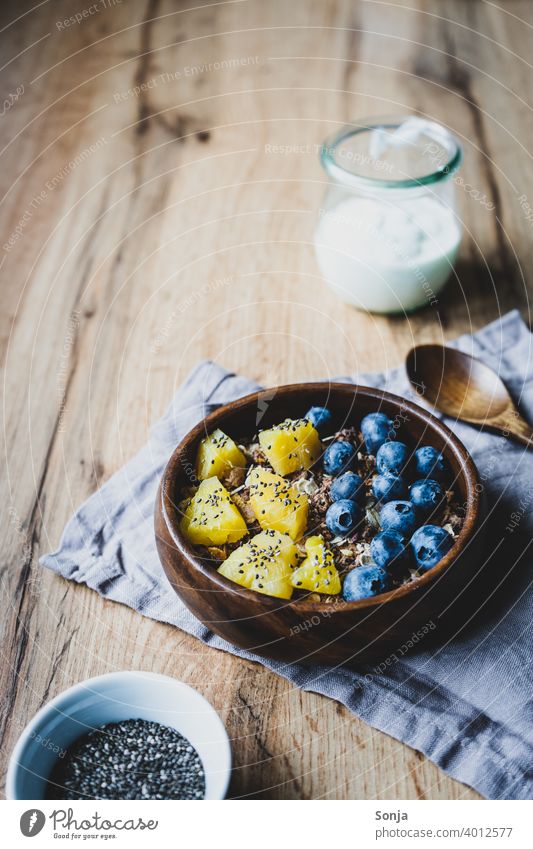 Healthy breakfast with muesli and fruit Cereal Oat flakes blueberry Pineapple breakfast table Breakfast Healthy Eating superfood Food photograph Table Wood