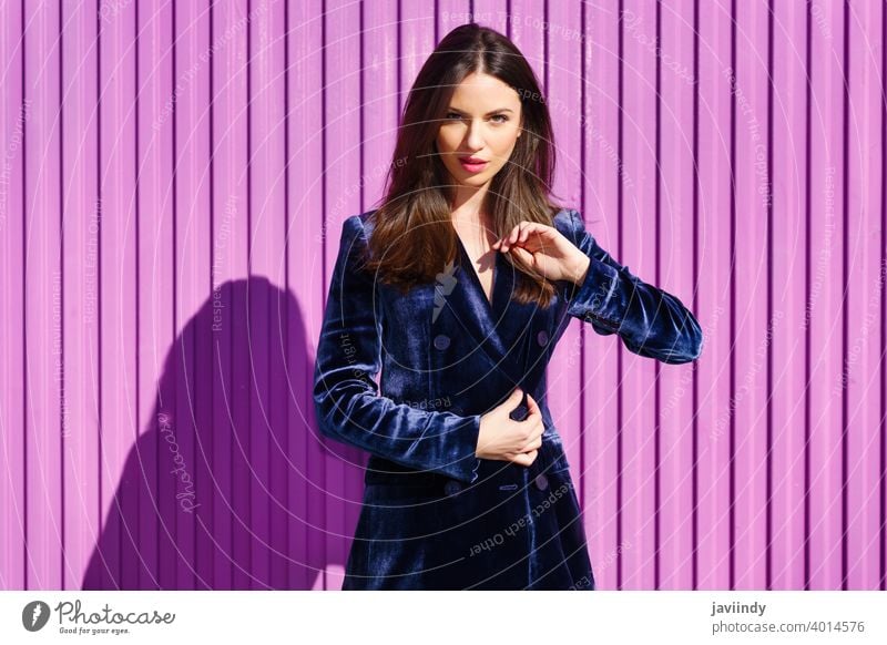 Woman wearing blue suit posing near pink shutter. woman girl person fashion model lifestyle female urban background lady one elegant building blind outside