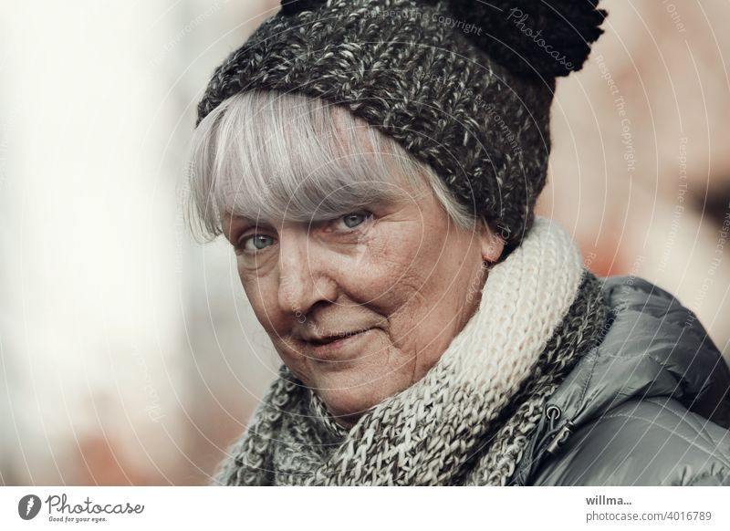 mischievous senior with bobble hat Senior citizen portrait White-haired Bobble hat Scarf Looking into the camera skeptical look skepticism Bangs asking