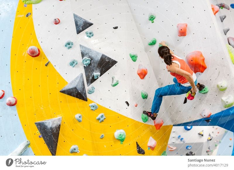 Rock climber woman looking at smartphone. climbing rock climbing indoor wall gym young training sport leisure active safety extreme person girl equipment