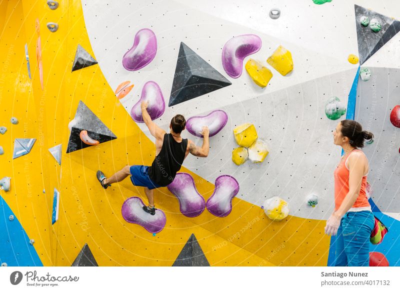 Rock climber woman looking at smartphone. climbing rock climbing indoor wall back view gym young training unrecognizable sport leisure active safety extreme