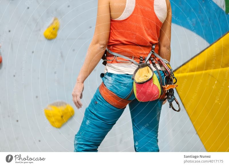 Woman getting ready for rock climb indoors. woman climber climbing rock climbing hands close up unrecognizable back view magnesium bag white wall gym young