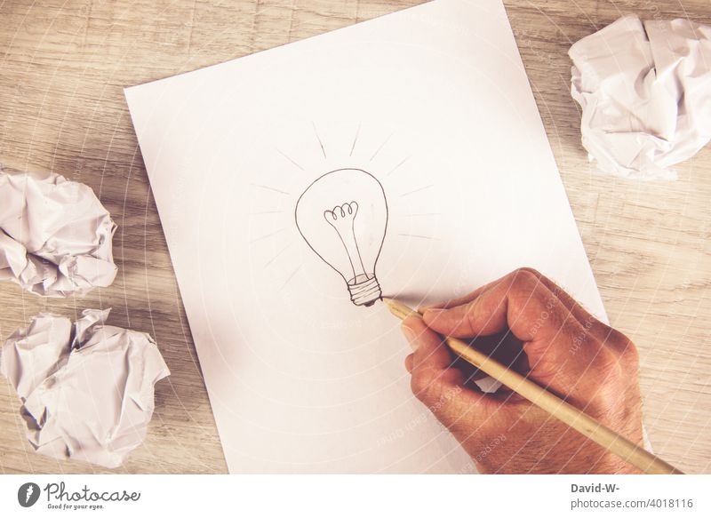 Man draws a light bulb on a piece of paper - concept / idea & idea Idea Result incursion Answer Ambition Electric bulb Creativity solution Target Education