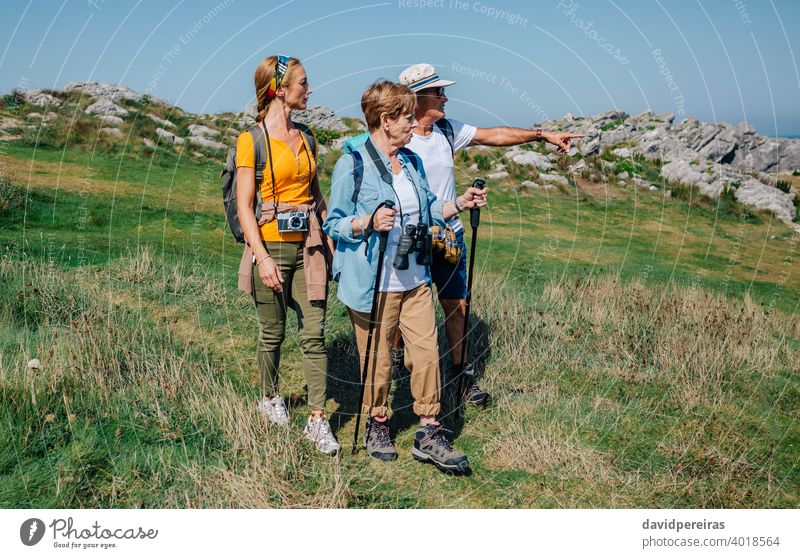 Family practicing trekking together outdoors hikers family countryside looking landscape nature journey summer recreation people hiking pointing backpack