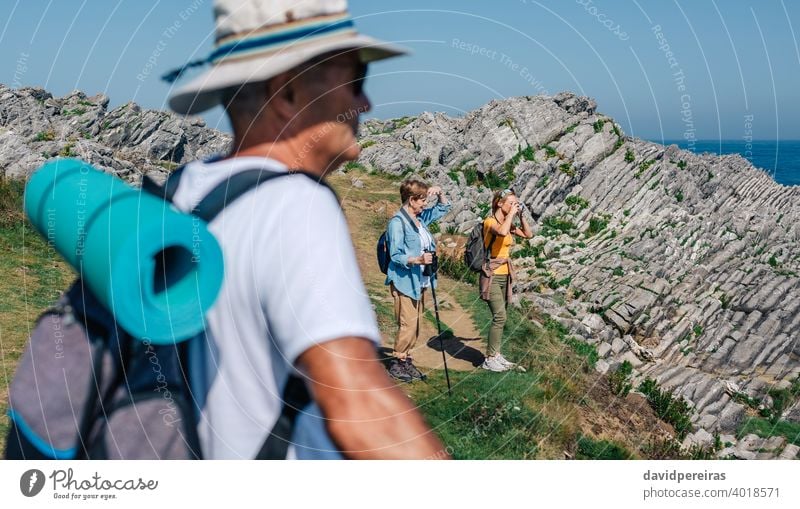 Family practicing trekking together outdoors hikers family camera taking picture landscape nature mountain countryside looking journey summer recreation people