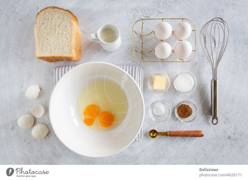 Flat lay of ingredients for preparing delicious French Toast  (or wentelteefjes in Dutch) on white grey background, food knolling french toast lunch sweet