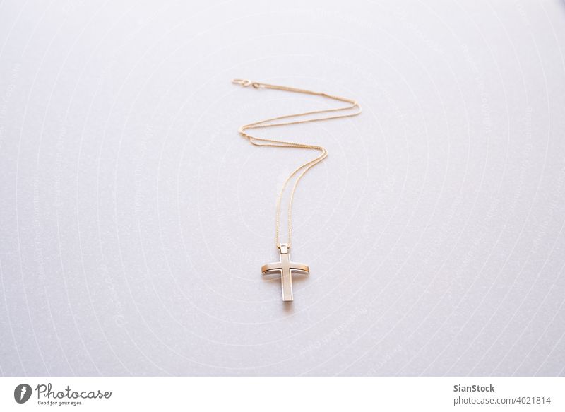 Christian cross and gold chain isolated on a white background. necklace pendant golden precious gift metal religious jewelry jewellery beautiful beauty fashion