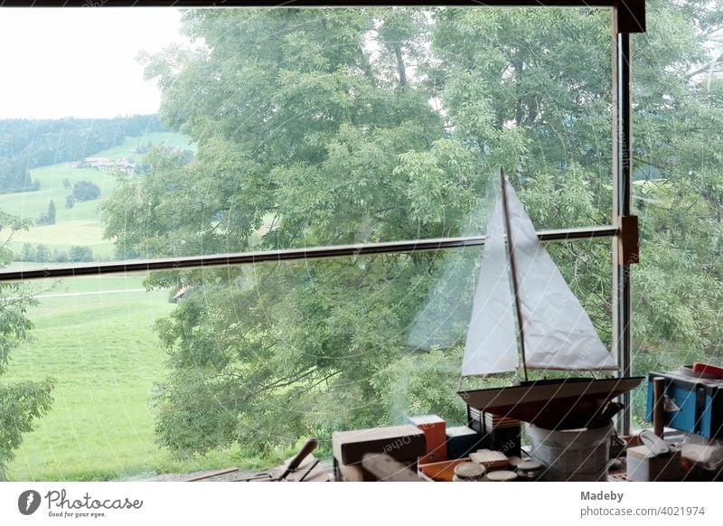 Sailing ship for Kimder with white sails on a workbench in an old farmhouse with a view of meadows and fields in Rudersau near Rottenbuch in the district of Weilheim-Schongau in Upper Bavaria