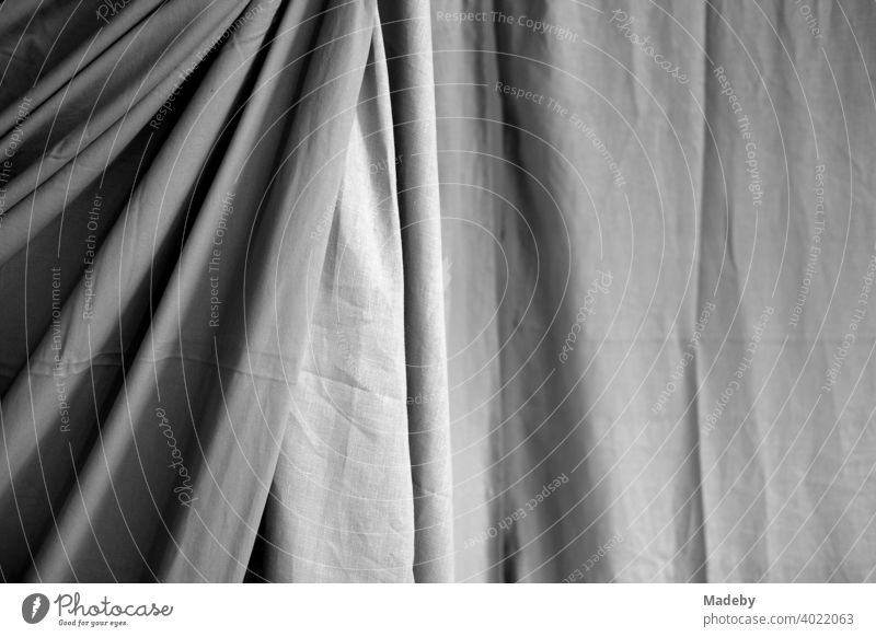 Large curtain made of fabric with folds and shadows in a designer apartment in Rudersau near Rottenbuch in the district of Weilheim-Schongau in Upper Bavaria, photographed in classic black and white