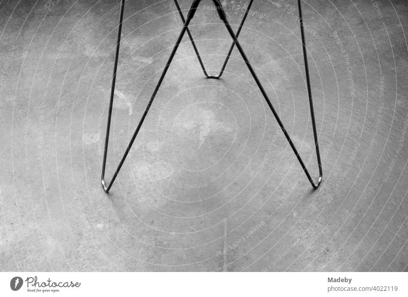 Wire frame as feet of a side table on grey concrete floor in a designer apartment in Rudersau near Rottenbuch in the district of Weilheim-Schongau in Upper Bavaria, photographed in classic black and white
