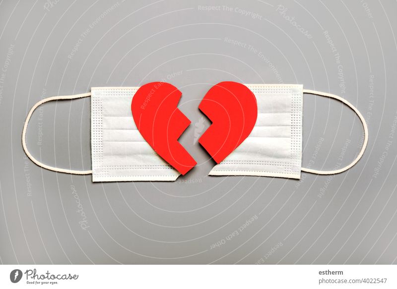 Protective surgical mask split in two with a broken heart.Concept of divorce due to the 2019 coronavirus pandemic protective surgical mask coronavirus masks