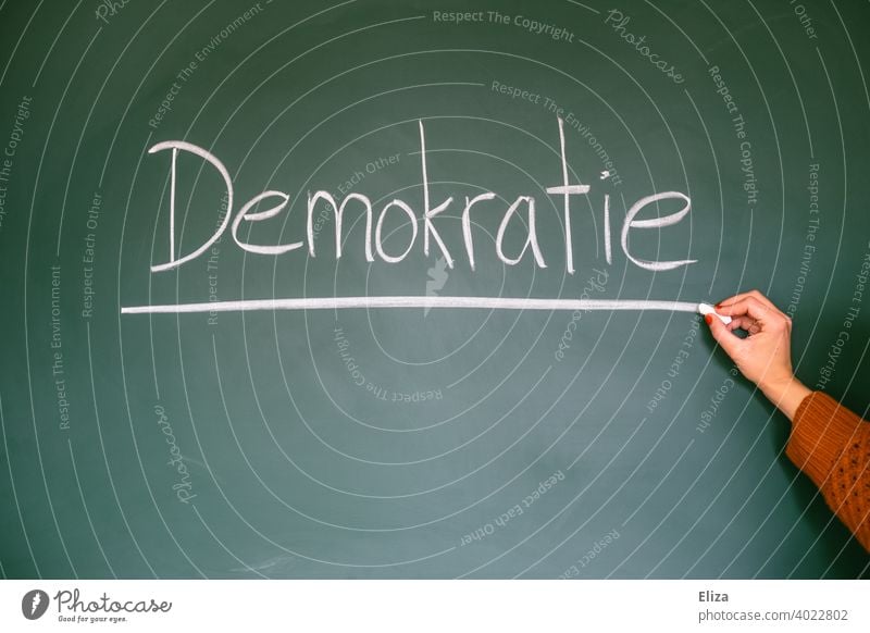 Democracy - word written on blackboard Blackboard authored Word Democratic policy Elections Select constitutional law Fairness Freedom politically state