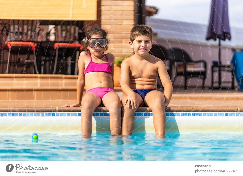 Two funny kids on a poolside active activity adorable aqua blue boy brother caucasian child childhood children cute edge family friends friendship girl glasses