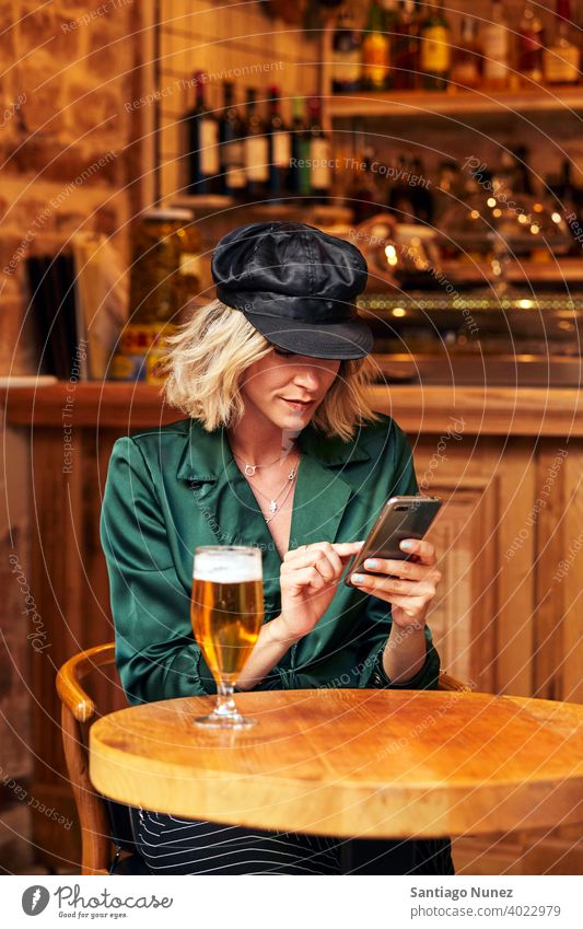 Woman looking at her smartphone at a bar. couple adult woman happy female restaurant lifestyle caucasian beautiful happiness drink fun joy romantic indoors