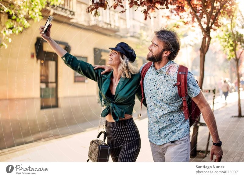 Couple walking on street taking a selfie couple adult woman people happy female lifestyle two caucasian beautiful happiness together drink smile fun love joy