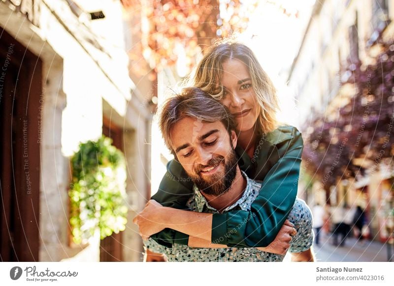 Woman piggyback on man on street. couple adult woman people happy female lifestyle two caucasian beautiful happiness together drink smile fun love joy boyfriend