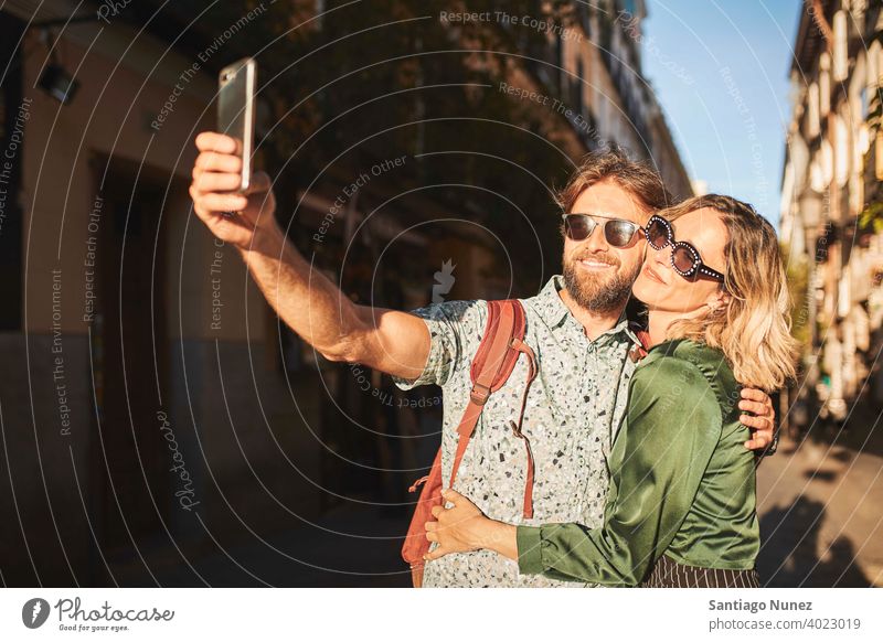 Couple walking on street taking a selfie couple adult woman people happy female lifestyle two caucasian beautiful happiness together smile fun boyfriend dating