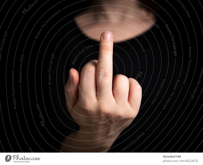 Hand flipping the finger,middle finger up,hand gesturing on dark background, agression,angry,hand, fuck off symbol concept sign gesture human person isolated