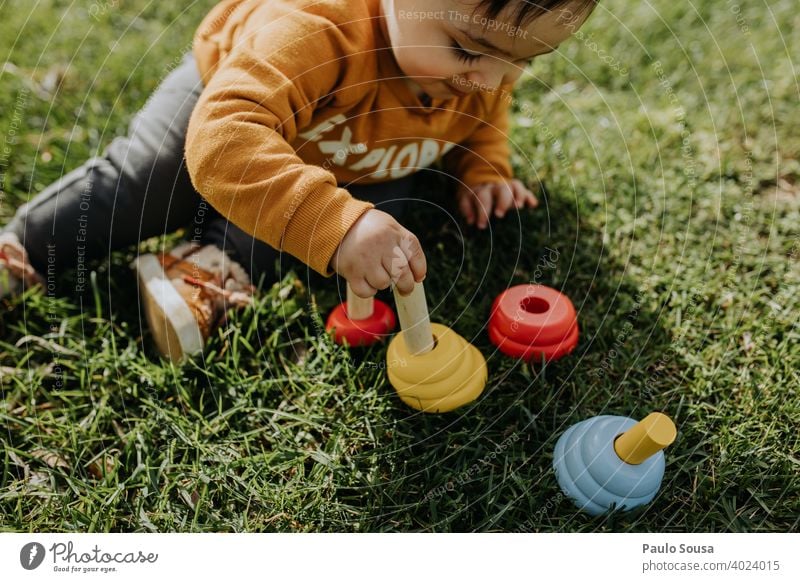 Child playing with toys in the grass Wood wooden Toys 1 - 3 years Caucasian Sit sitting Grass Toddler Human being Infancy Colour photo Playing Day Joy