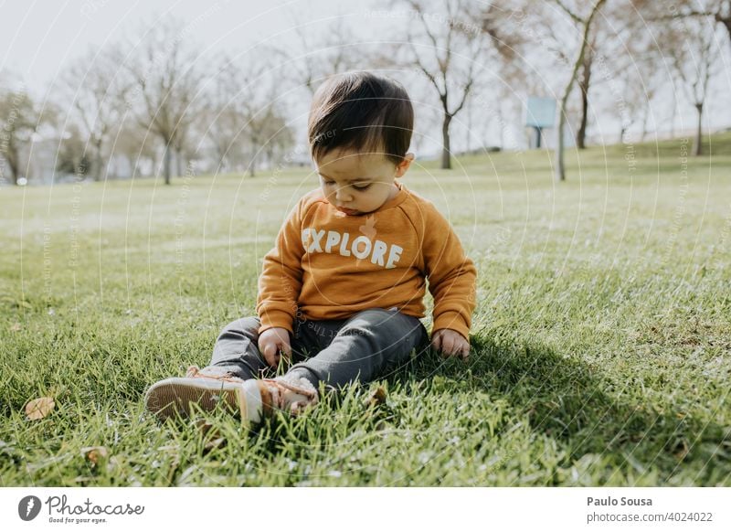 Child playing in the park Sit sitting Park Grass childhood 1 - 3 years Caucasian Colour photo Exterior shot Day Lifestyle Human being Infancy Happiness Toddler