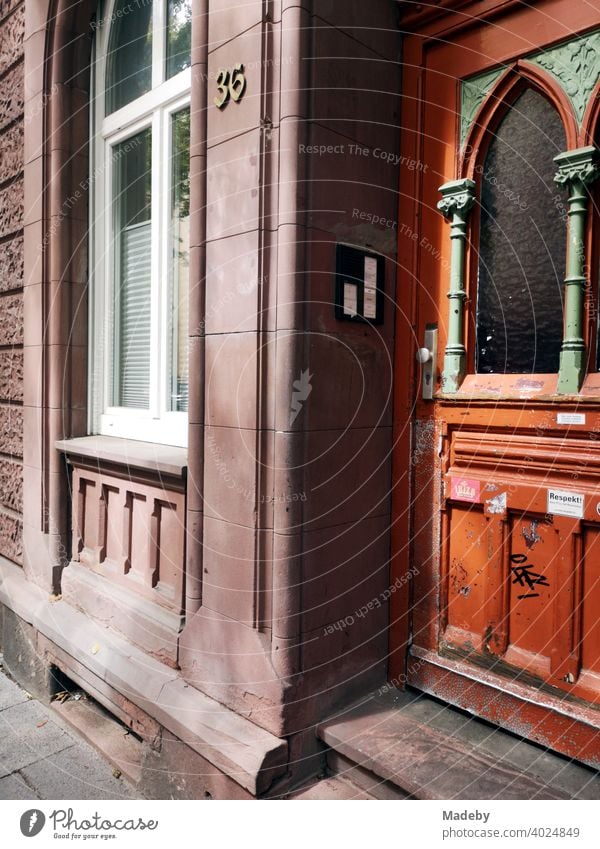 Old building made of red sandstone with beautiful wooden door in art nouveau style in sunshine in the north end of Frankfurt am Main in Hesse Wooden door