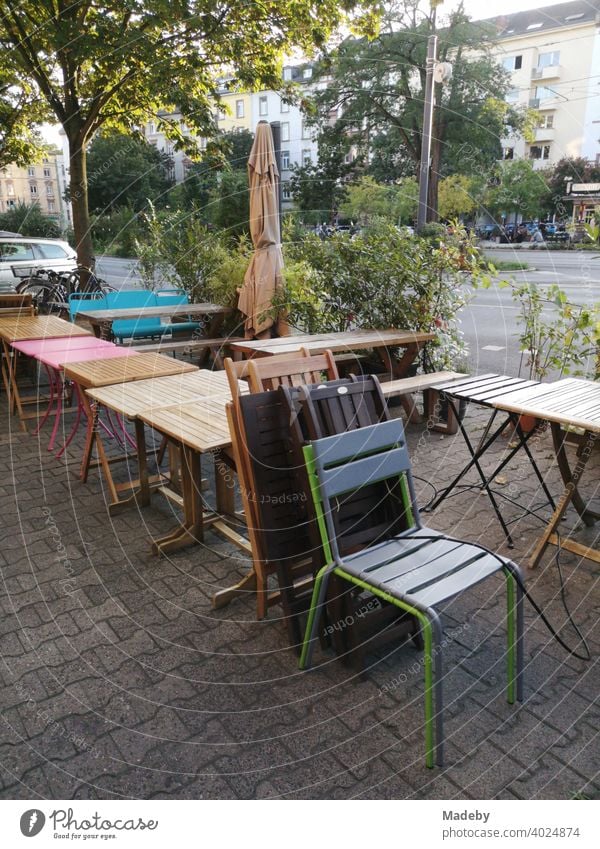 Bistro tables and chairs on the sidewalk with interlocking pavement in front of a closed bistro in the north end of Frankfurt am Main in the German state of Hesse