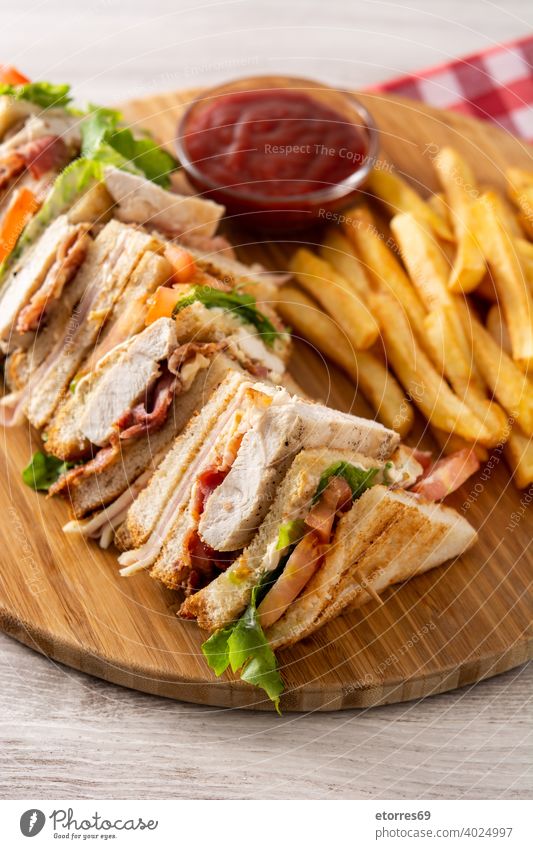 Club sandwich and French fries america bacon bread cheese chicken club club sandwich emeal fast food french fries ham homemade isolated ketchup lettuce lunch