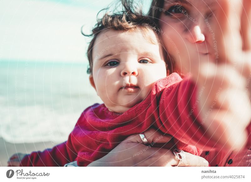 Happy family moment of a young mom enjoying a day on the beach with her baby love holidays happiness lifestyle sun sunny summer trendy fashion mother parenthood