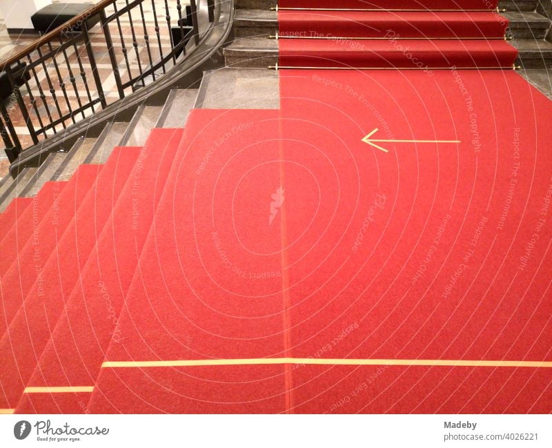 Red carpet with yellow arrow during Corona in the staircase of a museum in the capital Berlin, Germany Carpet Runner Arrow Clue Direction corona Safety