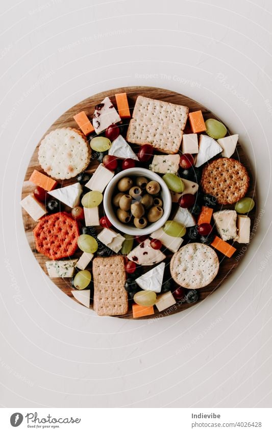 Cheese platter with different type of cheese. Camembert, cheddar, goat chesse, bleu, grapes and olive with crackers. Healthy vegetarian food idea. flat lay