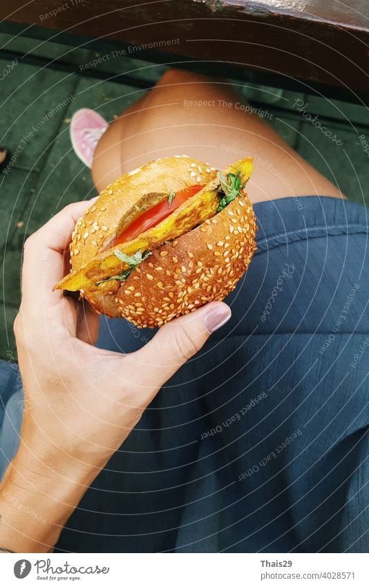 Young girl holding in female hands fast food burger, healthy calories meal, hungry woman with grilled hamburger top view dinner sandwich eat snack young lunch
