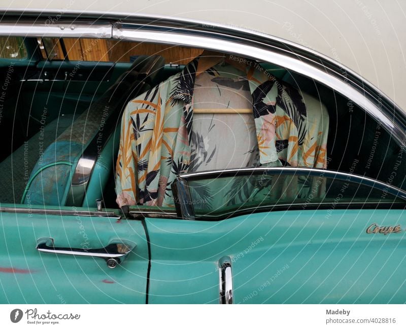 Wildly patterned Hawaiian shirt on a hanger in the rear of an American road cruiser of the fifties in turquoise at the Golden Oldies in Wettenberg Krofdorf-Gleiberg near Giessen in Hesse