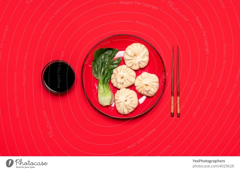 Baozi dumplings with bok choy on a red plate, top view. Homemade Chinese steamed food above view asian bao dumplings baozi bun chinese chinese food chopsticks
