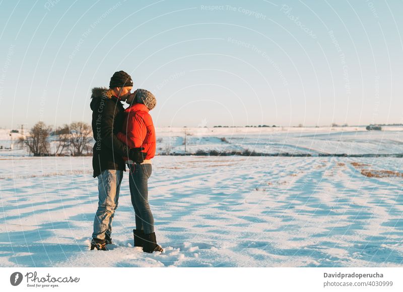 Couple kissing in snowy field couple winter countryside love romantic together relationship hug affection fondness embrace amorous tender bonding cuddle in love