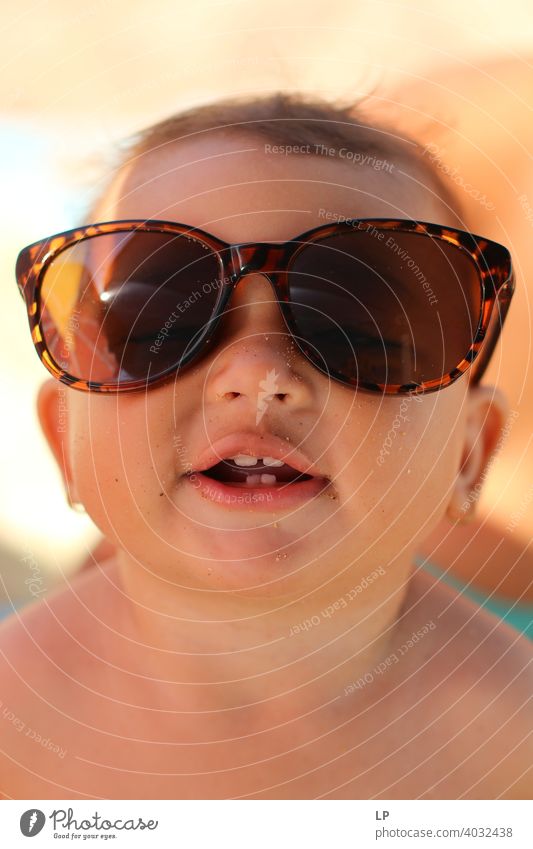 happy child wearing sunglasses and looking at the camera Summer Joy leisure vacation sweet smiling outside laugh joyful holiday healthy freedom excitement