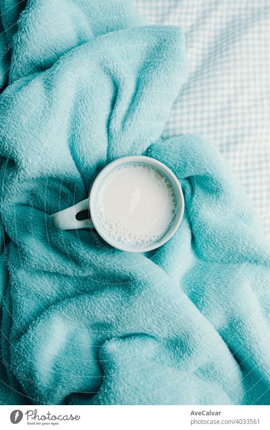 A cup of milk over a cozy blanket mood comfort home interior soft warm living pen planning book carpet copyspace life manufacture objects still bedroom braid