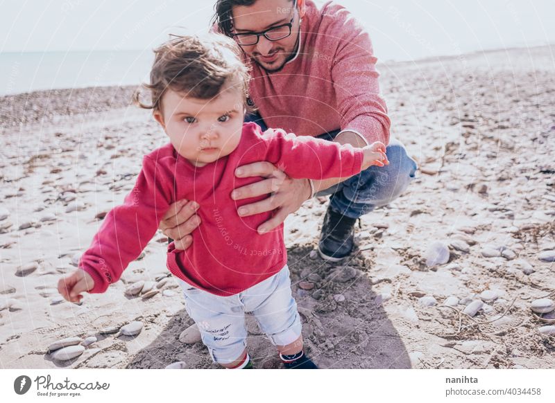 Young dad have a great day at the beach with his dauther family baby holidays happiness happy family time real people kid child little girl sunny father parent