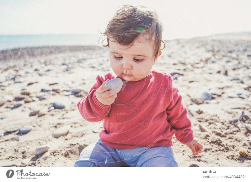 Little baby discovering the sand and sea holidays travel beach real curious playful sitting 8 months grow up life lifestyle cute adorable lovely jeans sun sunny