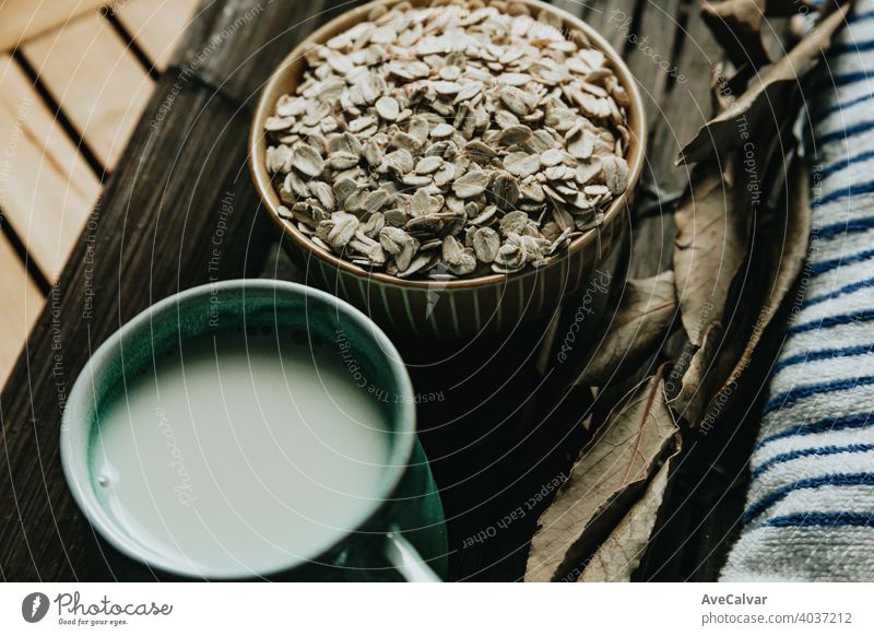 A breakfast of a cup of oat milk with oat seeds over a wooden plank food healthy grain organic nutrition cereal white natural oatmeal vegetarian ingredient diet