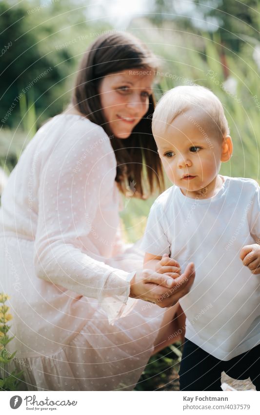 cute baby boy and his mother outdoors adorable bonding child childhood crawl crawling emotions explore exploring expression family fun garden grass green