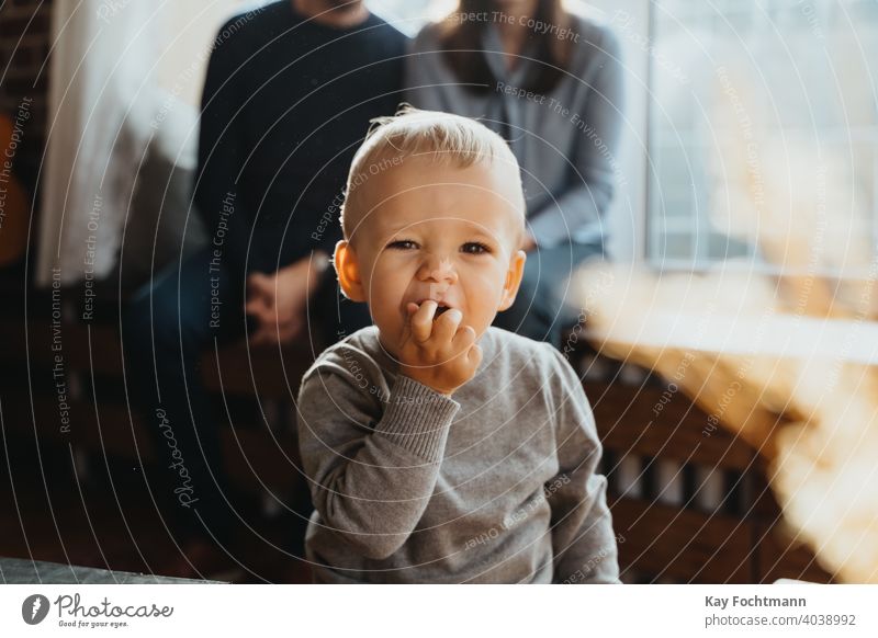 toddler eating adorable baby babyhood blonde boy child childhood cute emotions explore exploring expression family food fun happiness happy home interior human