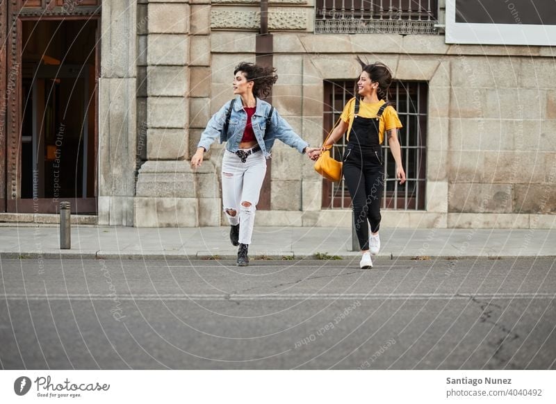 Two teenager girls running down street. madrid young people friendship lifestyle beautiful fun happy together leisure woman smiling teens cheerful female youth