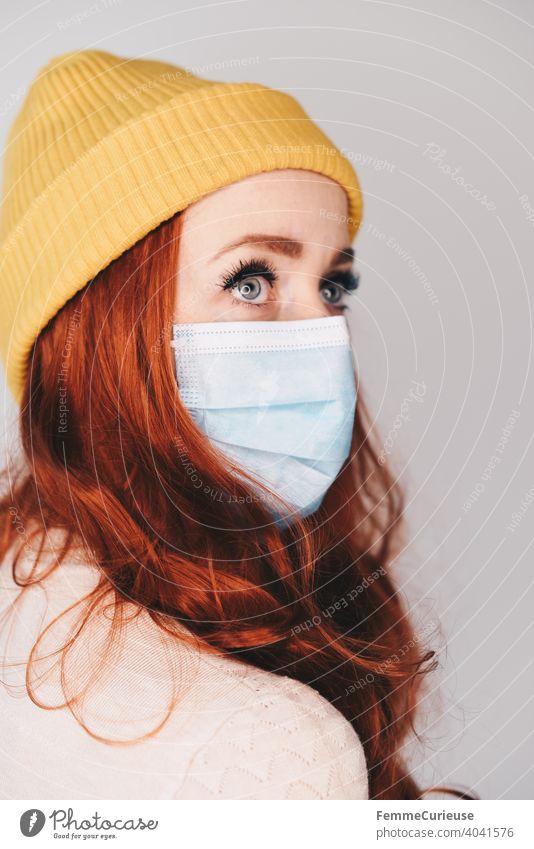Redhead young woman with yellow hipster beanie cap wears medical mask - Portrait with profile Mask Mask obligation Beanie hat Hipster Yellow Red-haired