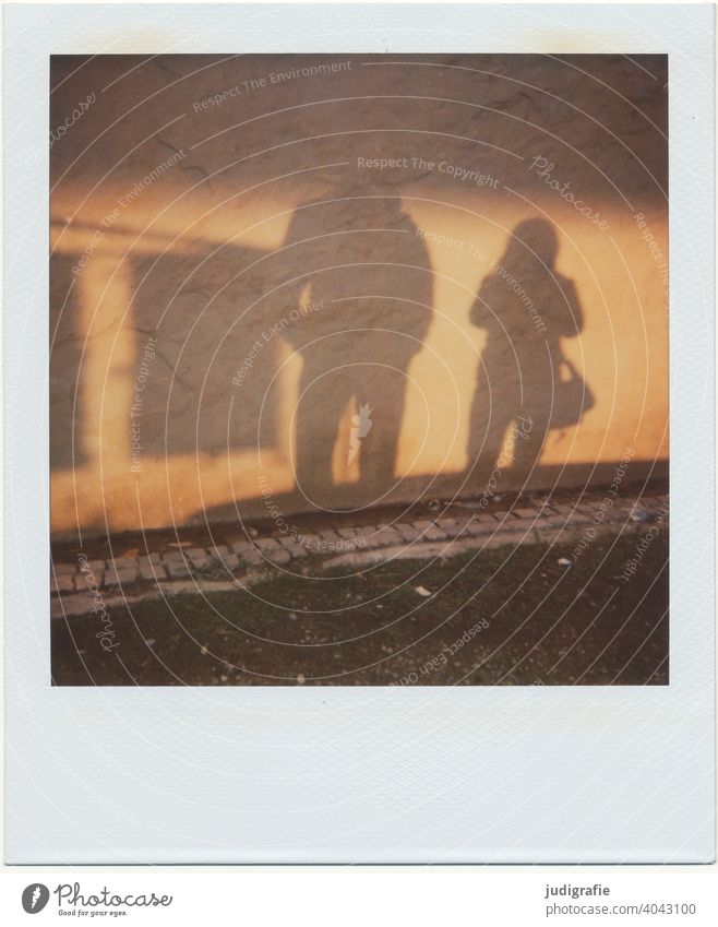 Shadow of couple on house wall on Polaroid Wall (building) Light Street Facade Wall (barrier) cobblestone pavement