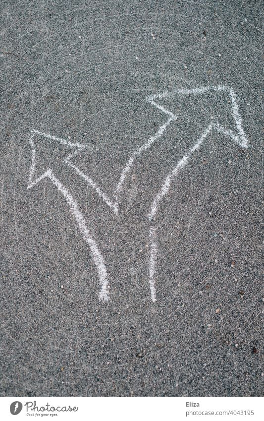 Two arrows in different directions made of chalk on asphalt. Decision, signpost. Arrow Decide Road marking Directions disparate Orientation Trend-setting Future