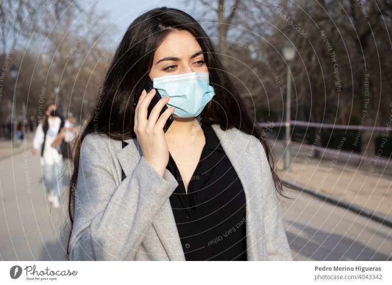 Woman with face mask talking with her mobile in a park. person adult pollution phone air care dust pandemic caucasian epidemic detail wearing allergy mouth