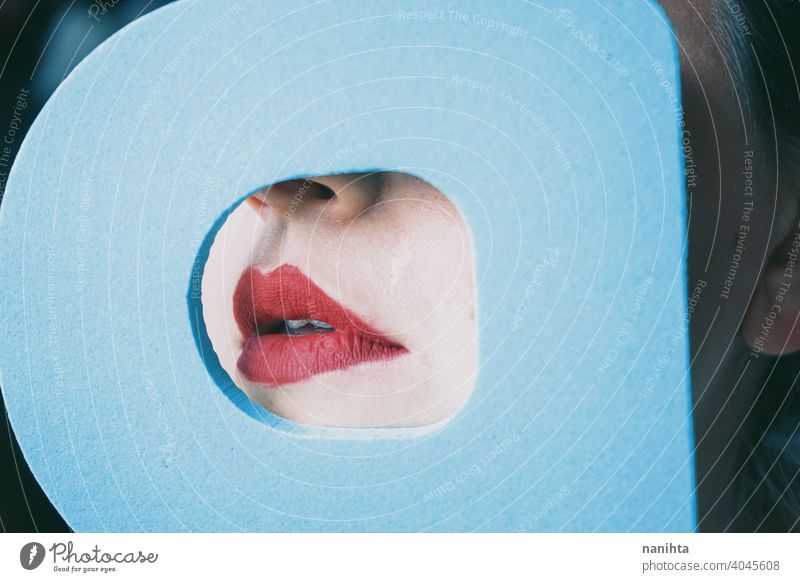 Young woman red lips behind a cover blue circle real covering color sexy sensual attractive contrast detail face shy timidity close quiet censorship censure