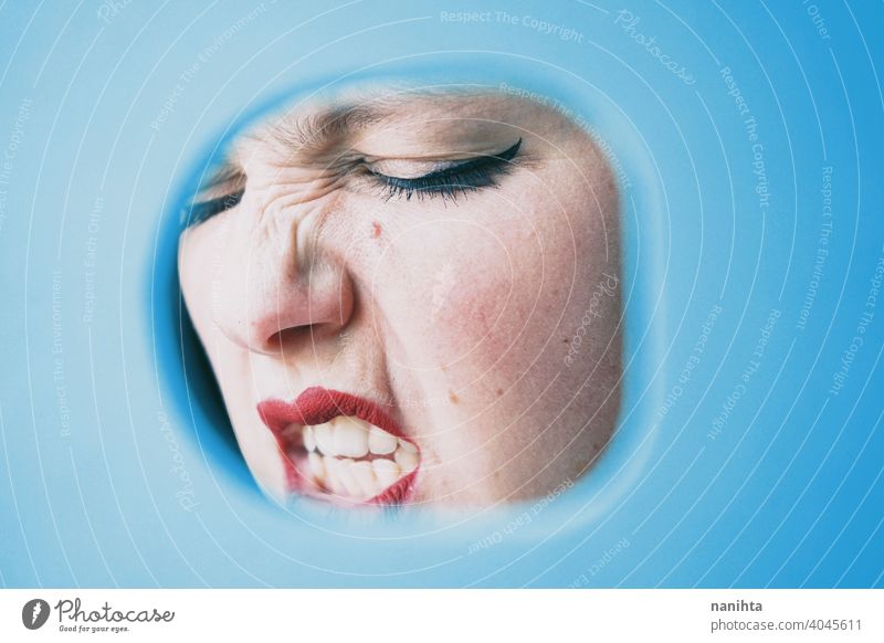 Conceptual image about stress, anxiety and hidden emotions woman lips real cover angry anger scream loud rage covering blue color sexy sensual eyes green eyes